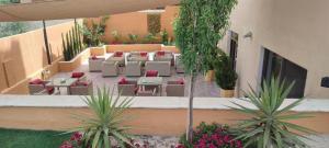 an outdoor patio with tables and chairs and plants at Black Iris Hotel II in Madaba