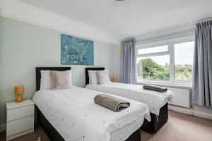2 Betten in einem Zimmer mit Fenster in der Unterkunft Cheerfull 3-Bedroom Home with parking & garden in Oxford