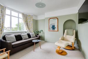 a living room with a couch and a chair at Cheerfull 3-Bedroom Home with parking & garden in Oxford