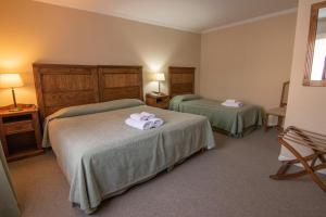 Habitación de hotel con 2 camas y toallas. en 349 Suites en El Calafate