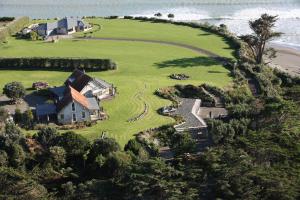 an aerial view of a house on a hill next to the ocean at Ahu Ahu Beach Villas in Oakura