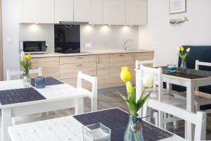 a kitchen and dining room with white tables and chairs at Zacisze Sosnowe in Łazy