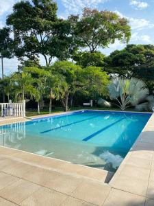 a blue swimming pool with trees in the background at Finca Villa Sofía Campestre con piscina in Anapoima