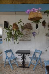 una pared con una estatua y dos sillas azules en Afonso Guest House en Panaji