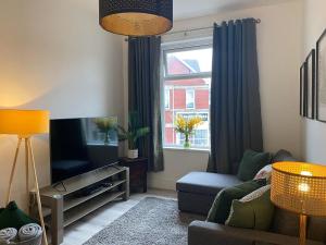 a living room with a couch and a tv and a window at The Retreats 1 Kenfig Hill Pet Friendly 2 Bedroom Flat with King Size bed twin beds and sofa bed sleeps up to 5 people in Kenfig Hill