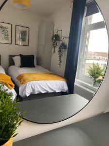 a mirror in a room with two beds and a window at The Retreats 1 Kenfig Hill Pet Friendly 2 Bedroom Flat with King Size bed twin beds and sofa bed sleeps up to 5 people in Kenfig Hill