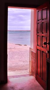 an open door to a beach with the ocean behind it at Leben am Atlantik hautnah spüren in Sal Rei