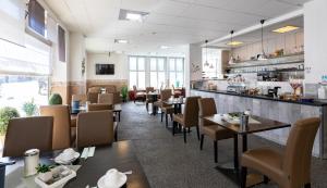ein Restaurant mit Tischen und Stühlen und einer Theke in der Unterkunft Stadt-gut-Hotel Großer Kurfürst in Emden