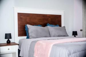 a bedroom with a large bed with a wooden headboard at Fabulous apartments in the new upmarkment and throbbing Lusaka area in Lusaka