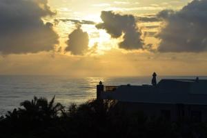 a sunset over the ocean with a person standing on a building at 2Bed 2Bath Vacation home with pool close to beach in Margate