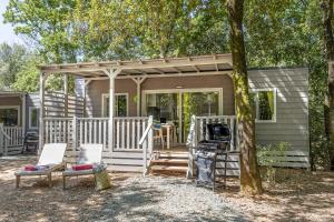 a tiny house with a porch and a grill at hu Park Albatros Village in San Vincenzo