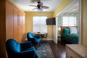 キーウェストにあるTwo Duval Street Suites w parking and poolのベッドルーム(ベッド1台、椅子、テーブル付)