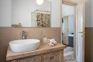 uma casa de banho com um grande lavatório branco num balcão de madeira em Il Mirto em Baja Sardinia