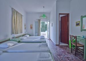 uma fila de camas num quarto com uma janela em Pension Paros Anna Spanou em Parikia