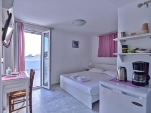 Sala de estar blanca con cama y mesa en Pension Paros Anna Spanou, en Parikia