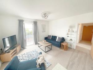 sala de estar con sofá azul y TV en Home Crowd Luxury Apartments, en Doncaster