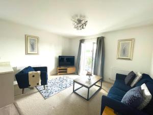 uma sala de estar com um sofá azul e uma televisão em Home Crowd Luxury Apartments em Doncaster