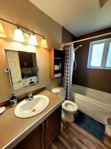 uma casa de banho com um lavatório, um WC e um espelho. em Maison St-Raymond Duplex em Matane