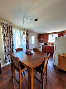 a kitchen with a wooden dining room table and chairs at Maison St-Raymond Duplex in Matane