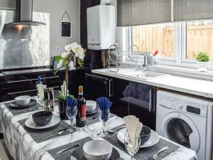 a kitchen with a washing machine and a sink at Meadow View in Lochgelly