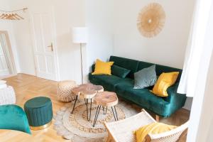 sala de estar con sofá verde y 2 mesas en Arbio Apartments near Mariahilferstraße, en Viena