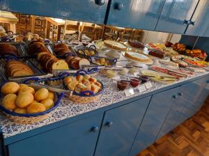 a buffet filled with different types of bread and pastries at Pousada Vista do Lago - HOSTEL in Gramado