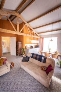 a living room with a couch and a table at De Kaasmakerij - Ruim vakantiehuisje op Huize Blokland in Hem