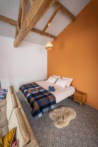 een slaapkamer met een bed en een bank bij De Kaasmakerij - Ruim vakantiehuisje op Huize Blokland in Hem
