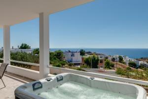 a bath tub on a balcony with a view of the ocean at Captain View in Ano Syros