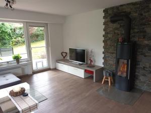 a living room with a fireplace and a tv at Haus Luise Weber in Hilders