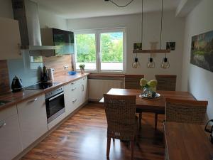 a kitchen with a wooden table and a dining room at Haus Luise Weber in Hilders