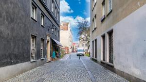 a cobblestone street with a van driving down a street at Dluga 66 Attic in Gdańsk