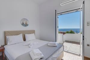 una camera da letto con un letto con asciugamani bianchi sopra di Captain View a Ano Syros