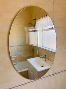 a bathroom with a mirror and a sink at The Valley, tranquil 3 bedroom home with pool in Midrand