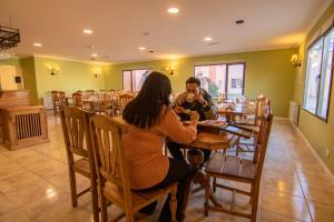 Ein Mann und eine Frau sitzen an einem Tisch in einem Restaurant. in der Unterkunft 349 Suites in El Calafate