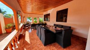 a dining room with a table and black chairs at Villa Milou in Baie Sainte Anne