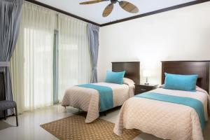 1 dormitorio con 2 camas y ventilador de techo en Diamante del Sol Ocean front, Jaco Paradise CR, en Jacó