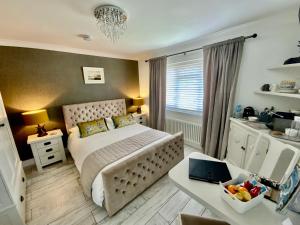 THE KNIGHTWOOD OAK a Luxury King Size En-Suite Space - LYMINGTON NEW FOREST with Totally Private Entrance - Key Box entry - Free Parking & Private Outdoor Seating Area - Town ,Shops , Pubs & Solent Way Walking Distance & Complimentary Breakfast Items في ليمنجتون: غرفة نوم مع سرير ومكتب مع الكمبيوتر المحمول