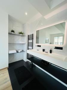 ein Badezimmer mit zwei Waschbecken und einem großen Spiegel in der Unterkunft Amazing Apartment 10min Palais des festivals in Cannes in Cannes