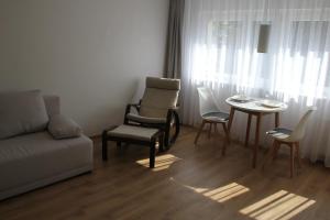 sala de estar con sofá, sillas y mesa en Przytulny, spokojny, wyposażony apartament, en Poznan