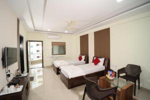 una camera d'albergo con due letti e una televisione di Hotel Bramha Inn a Dāpuri