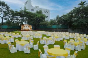 DāpuriHotel Bramha Inn Aundh Wakad Rooms Restaurant Banquet的一组白色的桌椅