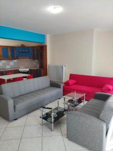a living room with two couches and a red couch at GCM 1 ROOMS kentro k parking in Katerini