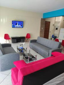 a living room with two couches and a tv at GCM 1 ROOMS kentro k parking in Katerini