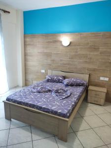 a bed with purple sheets and pillows in a room at GCM 1 ROOMS kentro k parking in Katerini