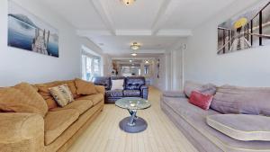 a living room with a couch and a table at Main Beach River Retreat - Wasaga Beach 1 - Main Strip - 95 Mosley St in Wasaga Beach