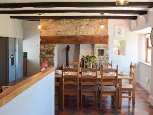 a kitchen and dining room with a table and chairs at Ty Celyn Farmhouse in Pont Yates