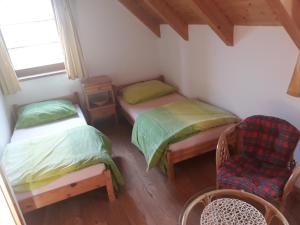 a small room with two beds and a chair at Chata Relax Moravec in Moravec