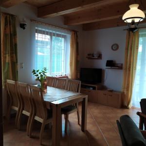 a dining room with a wooden table and chairs at Chata Relax Moravec in Moravec