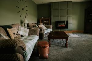 a living room with couches and a table and a fireplace at White Side Cottage in Haltwhistle